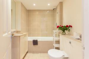 伦敦Harrods Flats的浴室配有卫生间、浴缸和水槽。