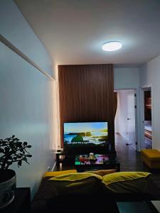 碧瑶YourHomeAway,LuxFlat at BristleRidge Baguio的客厅配有沙发和墙上的电视