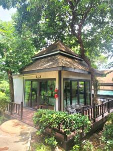 Ban Khao Rup Changสงขลาคีรี รีสอร์ท SongkhlaKeeree Resort的一个小房子,有门廊和一棵树