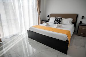 维多利亚Cittadella View Penthouse with Jacuzzi的一间卧室配有一张带橙色毯子的大床