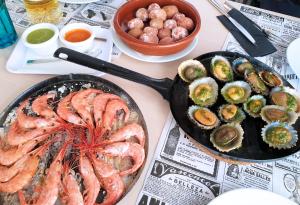 塞博河畔卡莱塔Evita Beach Suites Exclusivas的一张桌子,上面放着一盘虾和其他食物