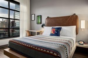 奥马哈Moxy Omaha Downtown的一间卧室设有一张大床和大窗户