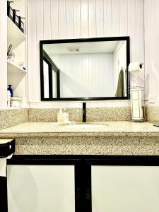 碧瑶YourHomeAway,LuxFlat at BristleRidge Baguio的一间带大镜子的盥洗盆的浴室