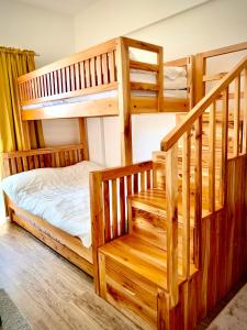 碧瑶YourHomeAway,LuxFlat at BristleRidge Baguio的一间带两张双层床的卧室和楼梯