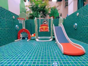 惠东摩洛哥绿屋森林的儿童游乐场配有游乐设备,位于瓷砖地板