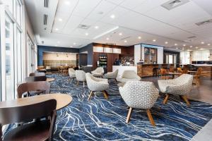 彭萨科拉Courtyard by Marriott Pensacola West的一个带桌椅的大堂和一间自助餐厅