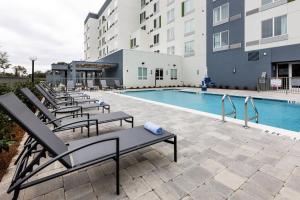 彭萨科拉Courtyard by Marriott Pensacola West的一座带躺椅的游泳池位于大楼旁