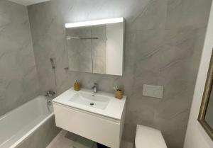 温特图尔goodstay的浴室配有白色水槽和浴缸。