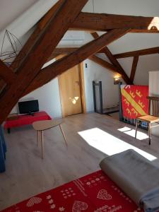 科尔马Gite Schlossberg的客厅设有木制天花板和红色地毯。