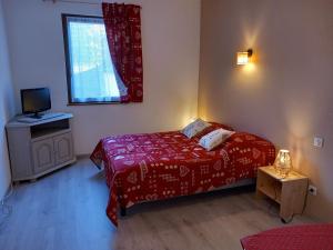 科尔马Gite Schlossberg的一间设有红色床和窗户的小卧室