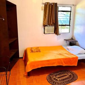 波尔多·格尼拉Palm House的一间卧室配有橙色的床和窗户。