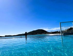 邦比尼亚斯Bombinhas Tourist Apart的蓝色海水和镜子的游泳池