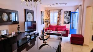 塞博河畔卡莱塔Evita Beach Suites Exclusivas的客厅配有红色沙发和电视