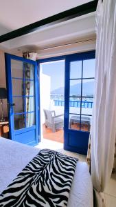 塞博河畔卡莱塔Evita Beach Suites Exclusivas的一间卧室设有斑马打印床和阳台