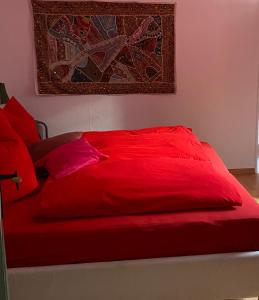 弗罗伊登施塔特1 - 2 Zimmer in historischem Altstadthaus的卧室内的红色床和红色枕头