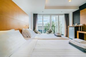 卡马拉海滩Vivace Hotel的一间带大床和阳台的大卧室