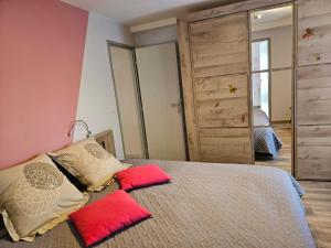 Chaux-des-CrotenayPont de la Chaux的一间卧室配有一张带红色枕头和镜子的床