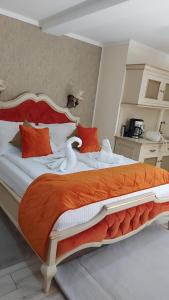 锡比乌Cochet House Sibiu的一间卧室配有一张带橙色和白色枕头的大床