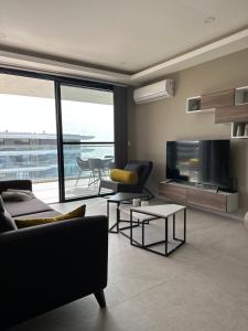 Sere KundaFar Out Apartments - Kololi Sands的带沙发和平面电视的客厅