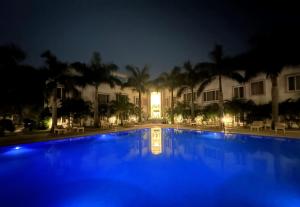 克久拉霍A S Hotels的一座游泳池,在晚上在建筑物前