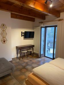 拉韦尔泰佐Osteria Vittoria的一间卧室配有一张床和一张书桌及电视