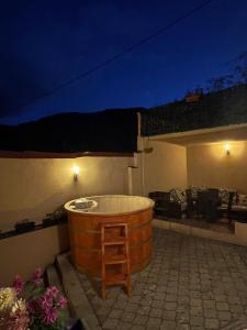 布拉索夫Londof Villa with panoramic view的大型木制浴缸,晚上坐在庭院里