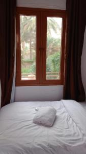 尼兹瓦Riad Nizwa的窗前带白色枕头的床