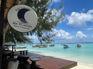 丽贝岛Sea To Moon Lipe的海滩上的标志,在水中划船