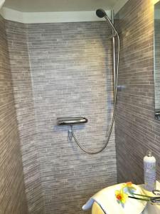 吕瑟希尔Mitt i vackraste Bohuslän的带淋浴的浴室(带瓷砖墙)