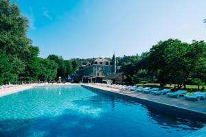 拉罗什-阿登弗洛雷阿尔拉罗什恩阿登酒店的一个带躺椅的游泳池以及一座房子