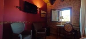 特连特Hotel Rural Abuelo Rullo的客厅配有椅子和窗户