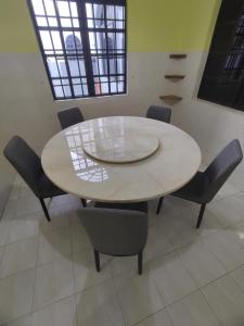 淡文Ipoh Tambun Sunway 5 Rooms Spacious Homestay的客房内的白色桌椅