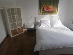 奥斯坦德Casa Frida的卧室配有白色的床和床头柜