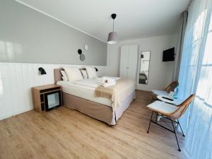 诺德代希Strandhuus Norddeich的卧室配有一张白色大床和一把椅子