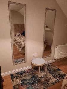 戈尔韦Radharc an Chuain 2 Bedroom Holiday Home的一间设有两面镜子、一张桌子和一张床的房间