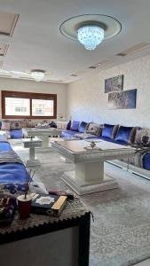梅克内斯appartement tout confort的客厅配有蓝色家具和吊灯。