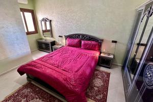 梅克内斯appartement tout confort的一间卧室配有一张带红色毯子的大床