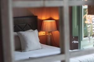 巴古尔La Indiana de Begur, Petit Hotel Boutique的一间卧室配有一张带灯和窗户的床
