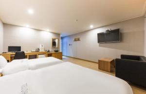 SeosanDaesan Hotel的酒店客房设有一张床和墙上的电视