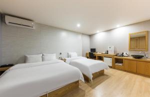 SeosanDaesan Hotel的酒店客房设有两张床和盥洗盆