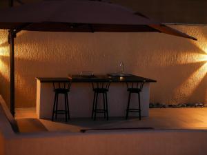 拉斯阿尔卡麦O2 pool villa的厨房岛设有2个酒吧凳和1个水槽