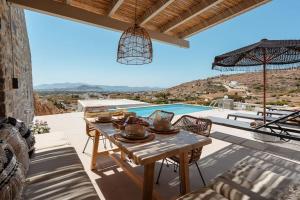 AgkidiaPleiades Villas Naxos2 (Hottub)的一个带桌子并享有游泳池景致的庭院