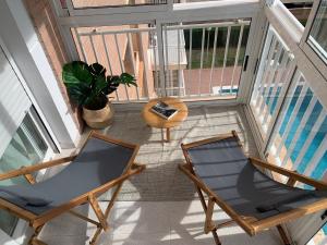 贝尼卡西姆APTO RESIDENCIAL EN BENICASIM的一个带两把椅子和一张桌子的阳台以及一个游泳池