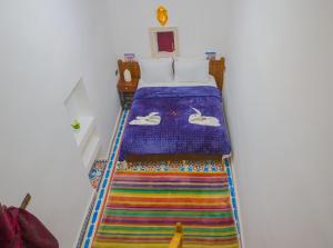 非斯Fes Hostel Zaouia的一间卧室配有一张带彩色地毯的床