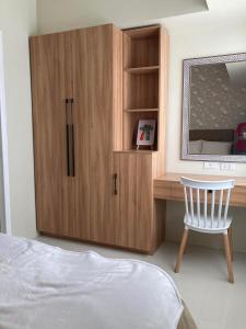 碧瑶Brenthill Condominium的一间卧室配有木制橱柜和椅子