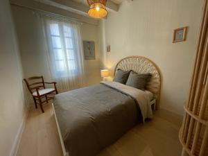 阿尔勒Résidence Léonard - Centre historique Arles的一间卧室配有一张带椅子的床和一扇窗户