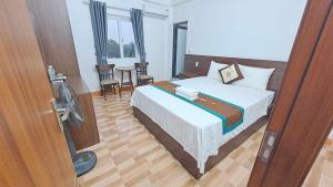 Thach Loi家庭过境酒店的一间带一张床的卧室和一间带风扇的房间