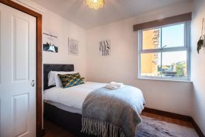 南安普敦Highland - 2 Bedroom Flat with Parking的一间卧室设有一张床和一个窗口
