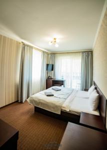 布克维Kasimir Resort Hotel & SPA的一间卧室设有一张大床和一个窗户。