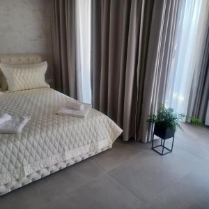 圣君士坦丁和海伦那Romantic Holiday Studio的卧室配有白色的床和盆栽植物